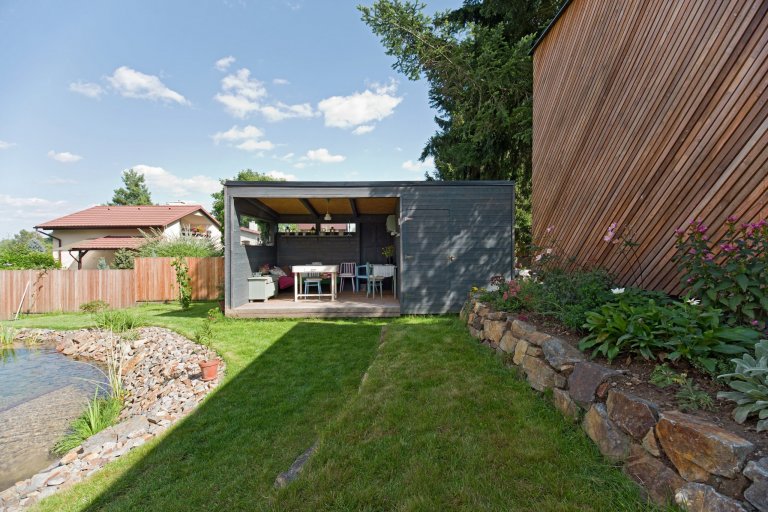 Architektonické řešení navazuje na zahrádkářskou minulost parcely a koncept projektu řadových domů. Protáhlá obdélníková stavba má plně prosklené přízemí, na…