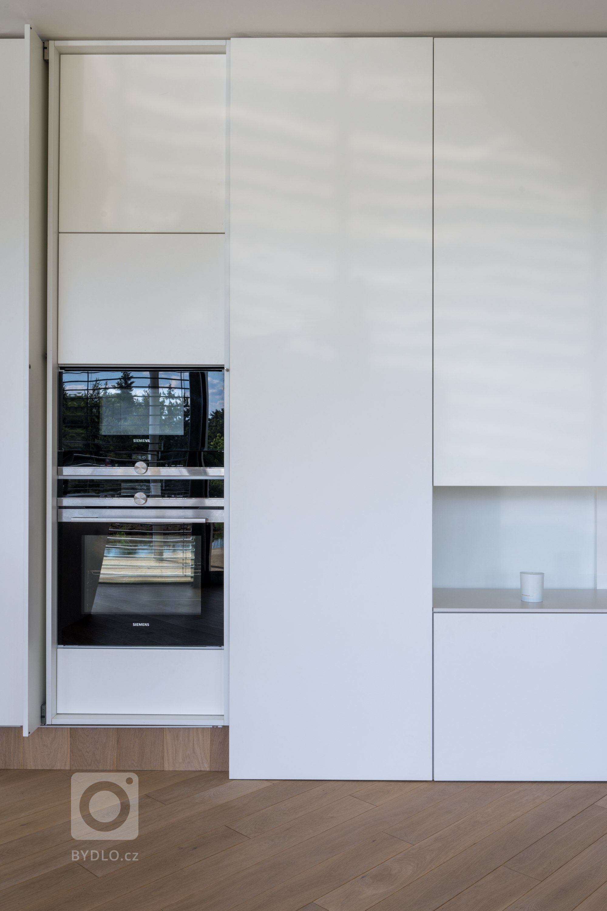 Z luxusního prostoru se rázem stane komfortní místo k vaření. Letmým dotykem otevřete speciální Hawa skříň, jejíž dvířka se elegantně zaparkují po straně a zpřístupní vám mikrovlnnou i horkovzdušnou troubu.