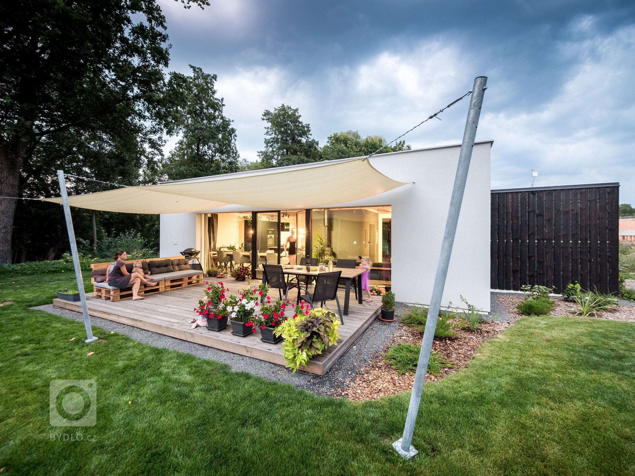 Základní hmotu domu ZEN HOME doplňuje přístavba z černých nesámovaných prken a výrazné textilní stínění terasy.